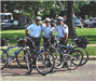three officers pose with bikes