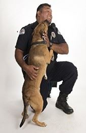 An animal control officer receives a kiss from a dog