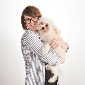 Shelter employee hugging small dog