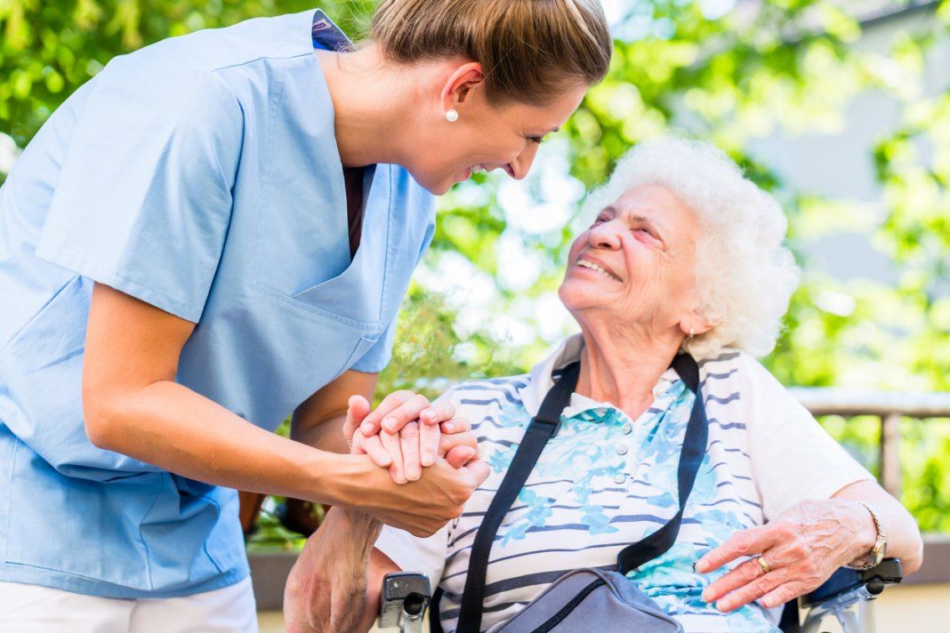 Nurse assisting elderly woman