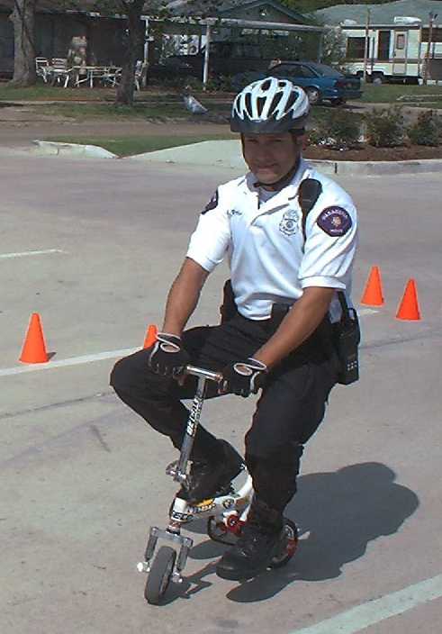 officer on scooter rides around cones